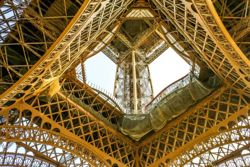 Close upward view of the Eiffel Tower wrought-iron lattice structure