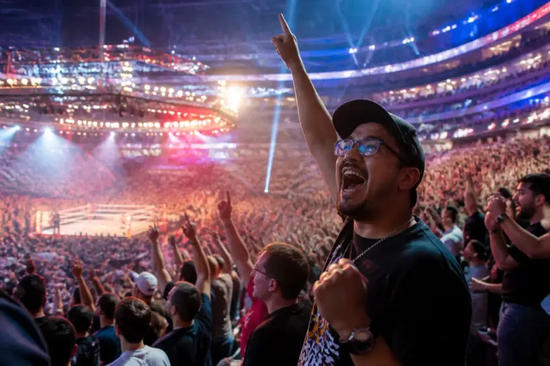 A packed stadium filled with excited wrestling fans during a WWE event.