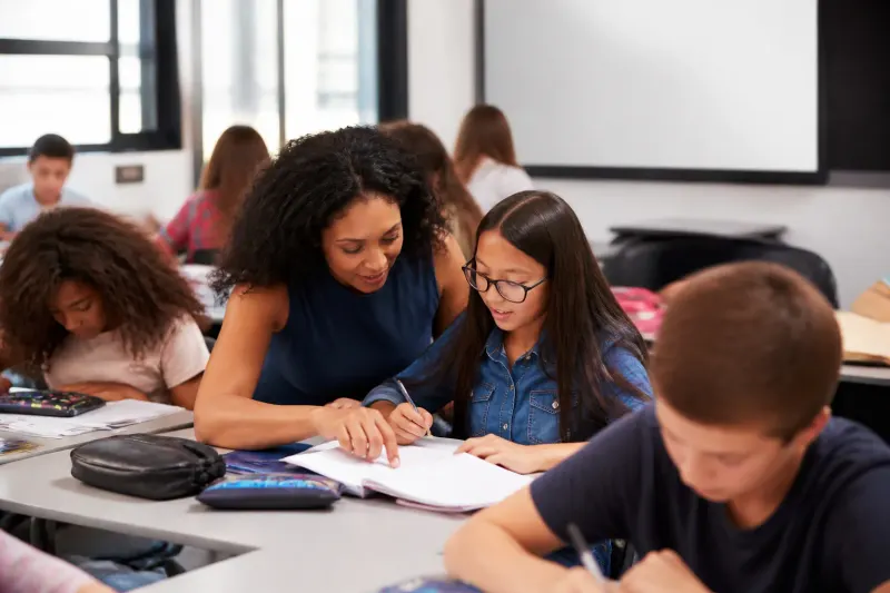 Students in a classroom engaging with a teacher illustrating mentorship's importance.