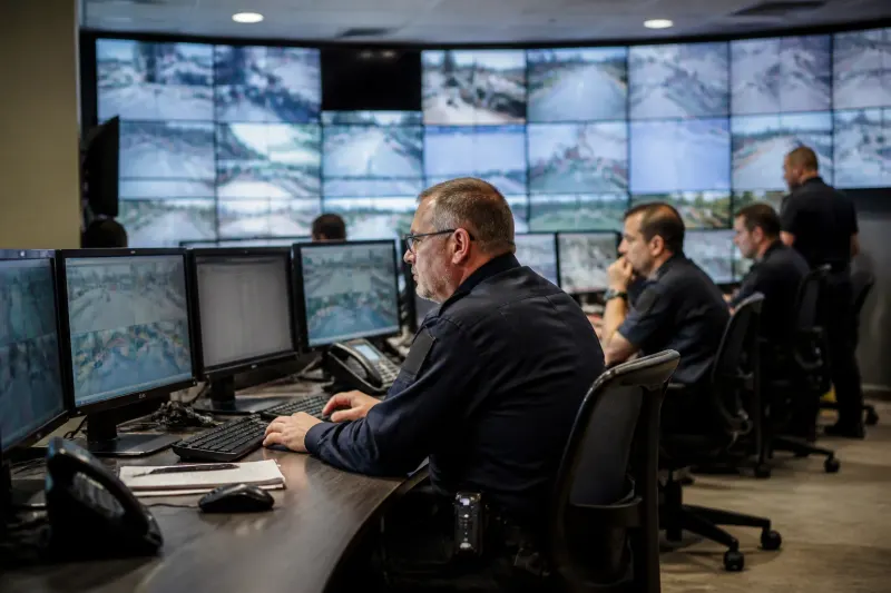 Police officers monitoring at a control center with surveillance feeds.