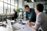 A team of diverse engineers collaborating on automation project proposals in a modern workspace.