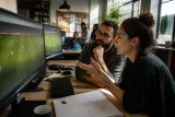 Game developers testing out FM26 with DLSS 5 enhancements in a bright office.