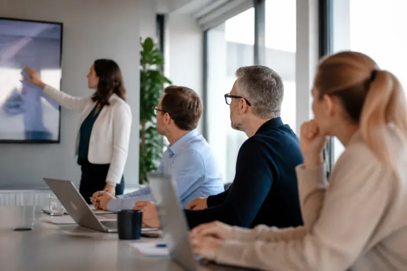A team of consultants reviewing AI-driven supply chain metrics