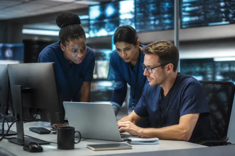 A hospital IT department with staff members monitoring security systems.
