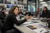 A chaotic meeting room with game developers discussing project designs for Mass Effect 5.